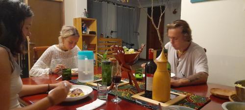 a group of people sitting at a table eating food at Aivilo Home in Kampala