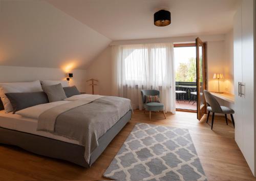Haus4Zimmer - Luxus mit Blick über den Bodensee - mit Garage في بريغنز: غرفة نوم بسرير ومكتب وطاولة