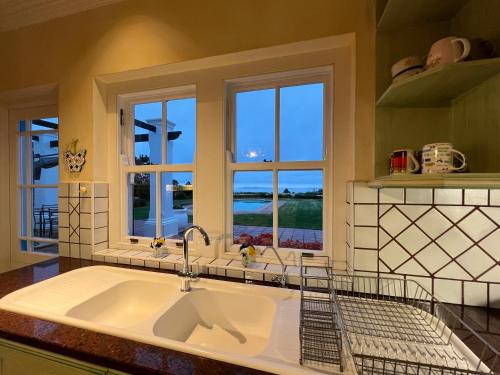 a kitchen with a sink and a large window at Greenhill Farm Manor House Plettenberg Bay - Private House Sleeps 8 in Plettenberg Bay