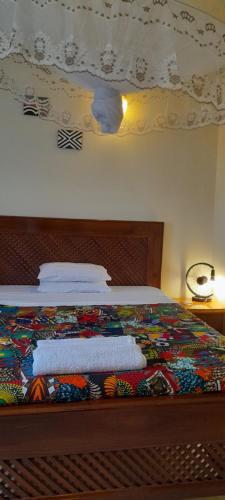 a bedroom with a bed with a colorful blanket on it at Aivilo Home in Kampala