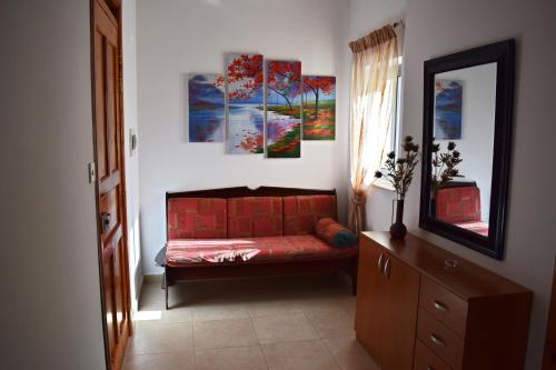 - un salon avec un canapé rouge et des peintures murales dans l'établissement Da Vinci 3 bedroom Apartment, à Mellieħa