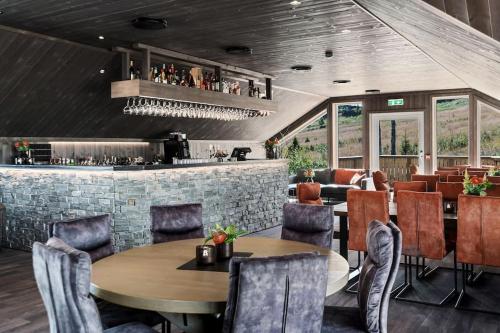 a restaurant with tables and chairs and a bar at Flott fritidsleilighet i Bualie på Golsfjellet in Gol