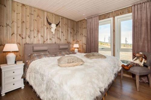 a bedroom with a bed and a antelope head on the wall at Ny, flott fritidsleilighet i Bualie på Golsfjellet in Gol