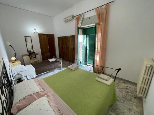 a bedroom with a bed with a green blanket on it at B&B Caterina in Biccari