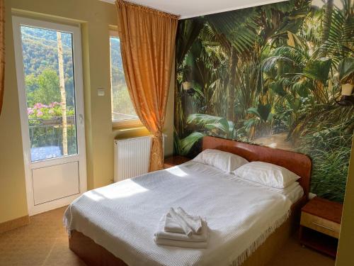 una camera da letto con un letto e due asciugamani di Pensiunea La Mesteceni -Zur Birke, Poiana Marului-Caras Severin a Poiana Mărului