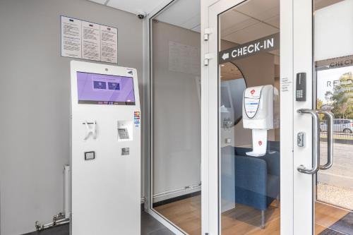 a door to a check in machine in a room at Reldor Motell in Pärnu