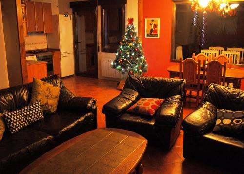 a living room with leather furniture and a christmas tree at Suite Rural Carenas in Carenas