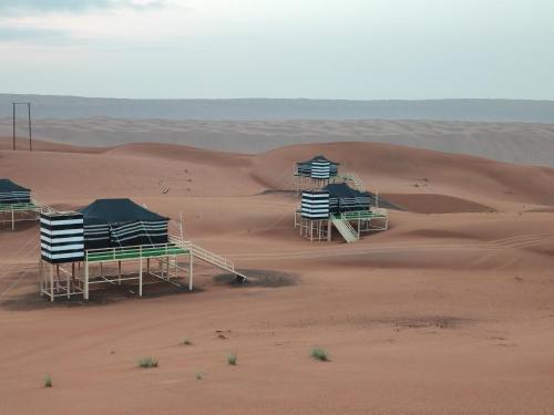 a group of tents in the middle of a desert at Oman desert private camp in Shāhiq