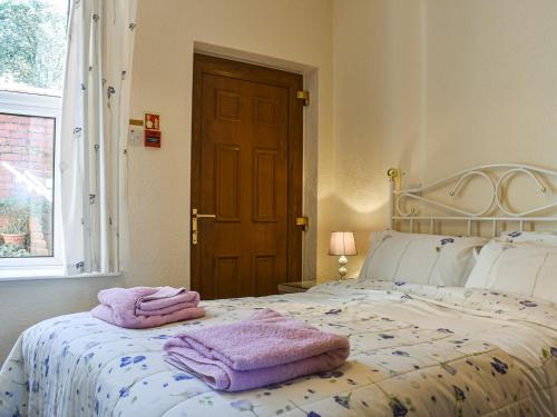 1 dormitorio con 1 cama con toallas en Whitby Apartment, en Commondale