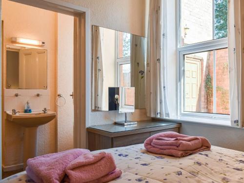 1 dormitorio con cama, lavabo y ventana en Whitby Apartment, en Commondale