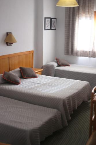 2 camas en una habitación de hotel con 2 camas sidx sidx sidx en HOSTAL LA POSADA en Espirdo