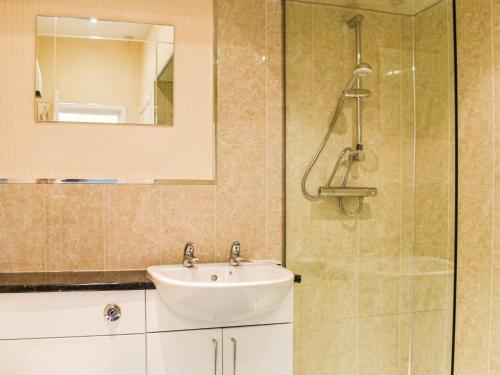 a bathroom with a sink and a glass shower at Grosmont Apartment in Commondale