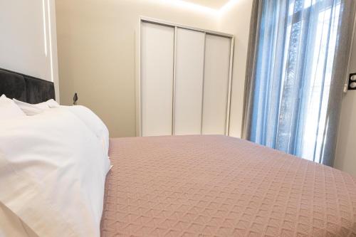 a bedroom with a bed with a pink comforter at BillMar Luxury Apartment in the center of Gythio in Gythio