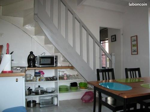 een keuken en eetkamer met een tafel en een trap bij Ty Yé in Sarzeau