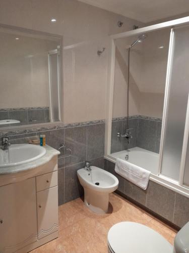 ein Badezimmer mit einem Waschbecken, einer Badewanne und einem WC in der Unterkunft Apartamento en Raxó in Pontevedra