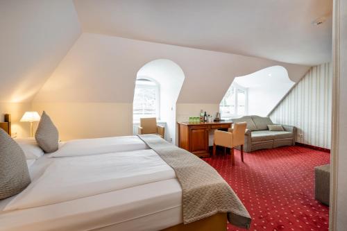 ザルツブルクにあるオーストロテル ザルツブルク アム ミラベルプラッツのベッドとデスクが備わるホテルルームです。
