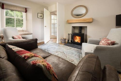 a living room with a couch and a fireplace at Crailing West Lodge in Jedburgh