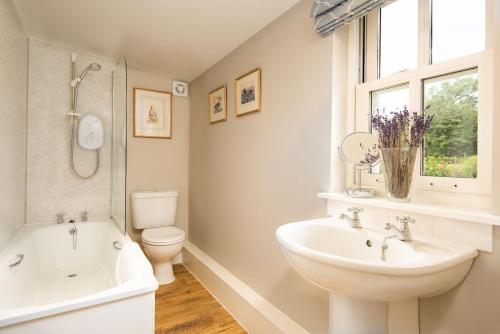 a bathroom with a sink and a tub and a toilet at Crailing West Lodge in Jedburgh