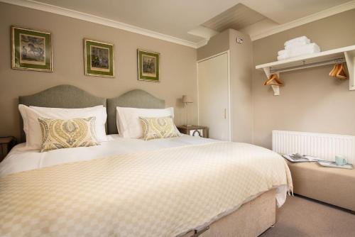 a bedroom with a large bed with white sheets and pillows at Crailing West Lodge in Jedburgh
