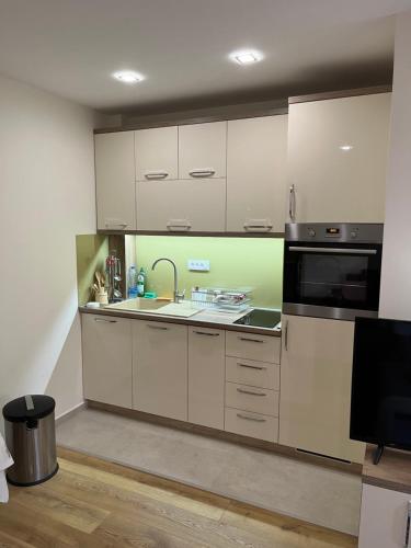 a kitchen with white cabinets and a microwave at Apartmani Twins Zlatibor in Zlatibor