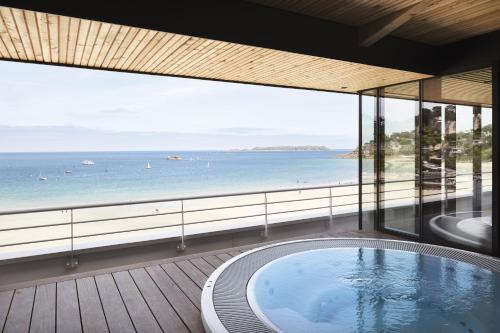 a view of the ocean from a house with a hot tub at Grand Hôtel Perros-Guirec in Perros-Guirec