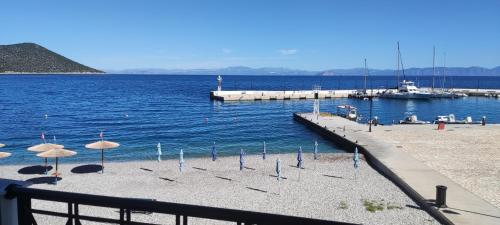 a beach with umbrellas and a dock in the water at Hotel Blue Sea in Tiros