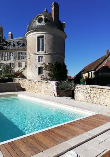 une maison avec piscine devant un immeuble dans l'établissement CHATEAU DES BARRES, à Sainpuits