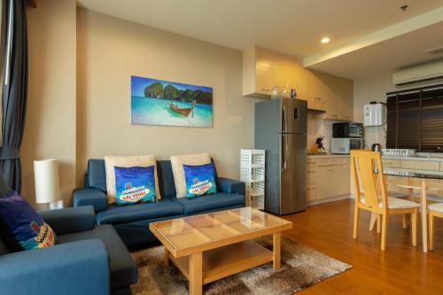 a living room with a blue couch and a table at Deluxe 1bedroom Hua Hin Seaview Beachfront Project in Ban Bo Fai