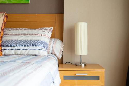 a bedroom with a bed and a lamp on a night stand at Deluxe 1bedroom Hua Hin Seaview Beachfront Project in Ban Bo Fai