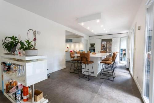 une cuisine aux murs blancs et un bar avec tabourets dans l'établissement 230m2 sur 3800m2 - jacuzzi 6 places - 16pers max, à Pontault-Combault