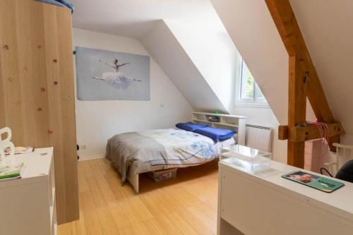 a small bedroom with a bed in a attic at 230m2 sur 3800m2 - jacuzzi 6 places - 16pers max in Pontault-Combault