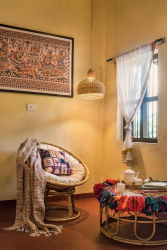 a living room with a chair and a table at SaffronStays Sattva - pet and eco-friendly villa in Mumbai's outskirts in Pen