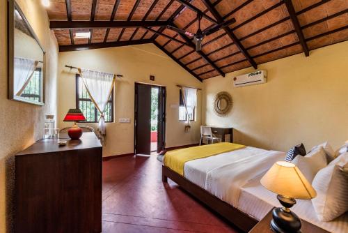 a bedroom with a large bed and a wooden ceiling at SaffronStays Sattva - pet and eco-friendly villa in Mumbai's outskirts in Pen