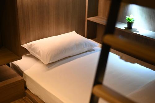 a bed in a room with a pillow on it at Moose Hotel Nimman in Chiang Mai
