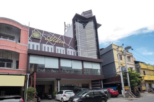 a building with cars parked in front of it at Collection O 91714 Hotel Alden in Makassar