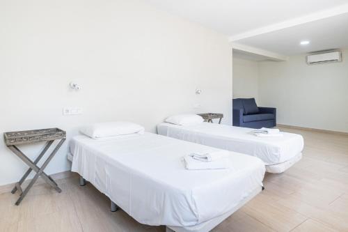 una habitación de hospital con 2 camas y una silla en Apartamentos La Rosita Old Town B-21 en Benidorm