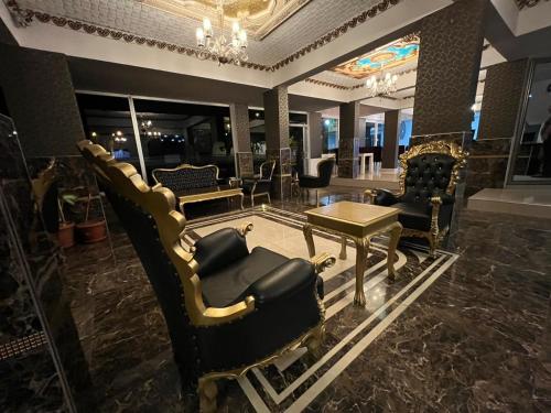 a salon with chairs and a table in a room at Grand Black Hotel in Mersin