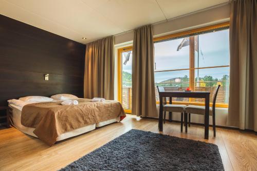 a bedroom with a bed and a table and a window at Skihouse Apartment in Levi