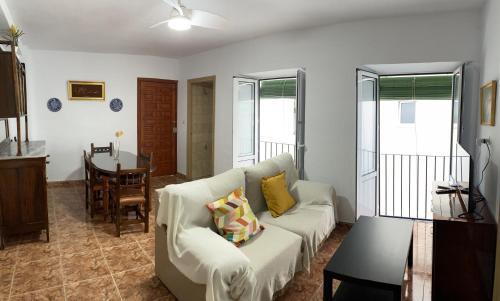 een woonkamer met een witte bank en een tafel bij Casa Pepe La Rosa in Tolox