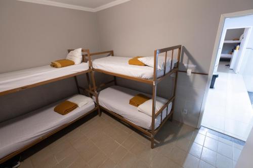 a room with three bunk beds and a mirror at Hostel Diniz in Vitória