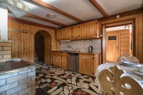 Una cocina con gabinetes de madera y encimera. en Gościniec u Marzeny, en Bukowina Tatrzańska