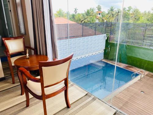 Habitación con mesa, silla y ventana en Sundale Hotel, en Divulapitiya