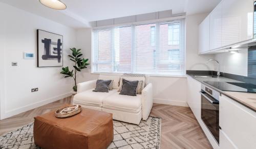 a living room with a white couch and a kitchen at Royal House Stylish Apartments - Chester in Chester
