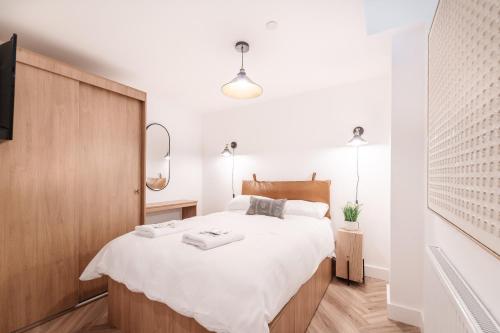a bedroom with a large bed with white sheets at Royal House Luxury Apartments - Chester in Chester