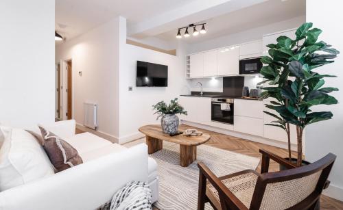 a living room with a white couch and a table at Royal House Stylish Apartments - Chester in Chester