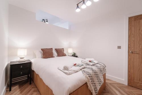 a bedroom with a bed with two pairs of socks on it at Royal House Stylish Apartments - Chester in Chester