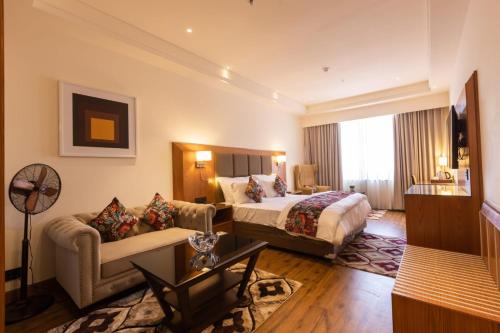 a hotel room with a bed and a couch at Clarks Inn Express Ludhiana in Ludhiana