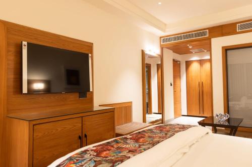a bedroom with a flat screen tv and a bed at Clarks Inn Express Ludhiana in Ludhiana