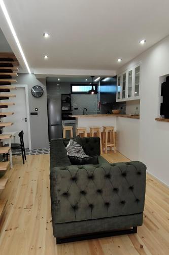 a living room with a couch and a kitchen at Casa d´ Avó Glória in Alvoco das Várzeas