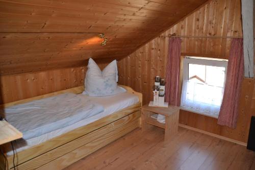 a bed in a wooden room with a window at Auszeit by Annette in Hohenwarth
